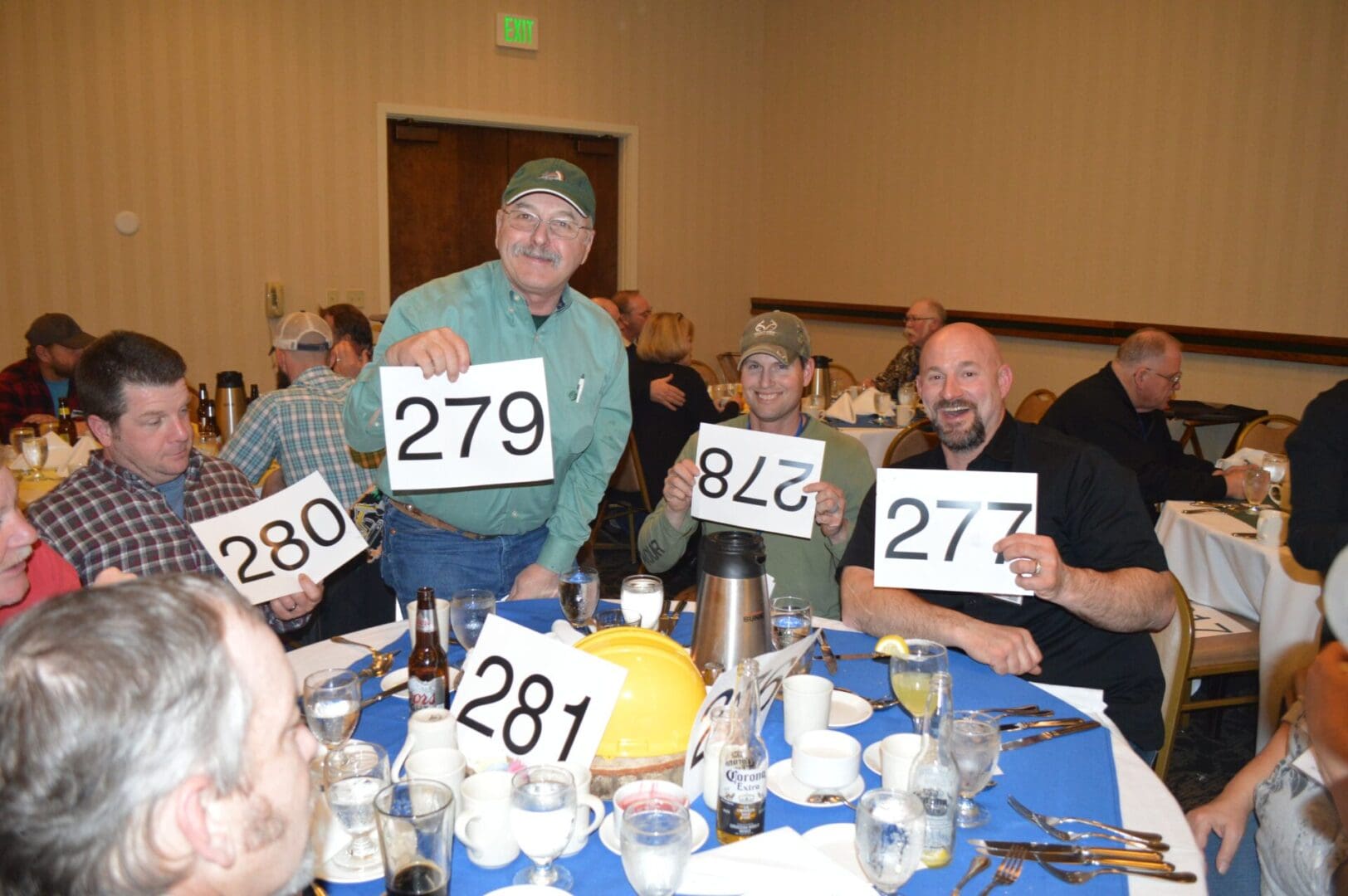 A group of people sitting at a table holding up signs.